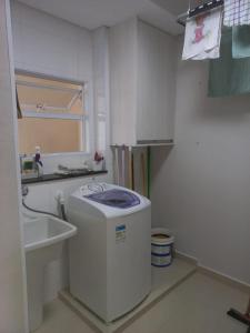 瓜鲁雅Apto Guarujá Pitangueiras的一个带水槽和洗衣机的小厨房
