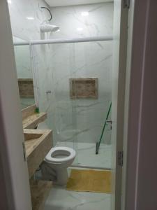 瓜鲁雅Apto Guarujá Pitangueiras的一间带卫生间和玻璃淋浴间的浴室