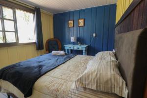 圣若泽杜斯皮尼艾斯Chácara do Sapé的一间拥有蓝色墙壁和一张大床的卧室