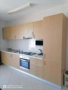 萨尔雷Solaren Apartments Boavista的厨房配有木制橱柜和炉灶烤箱。