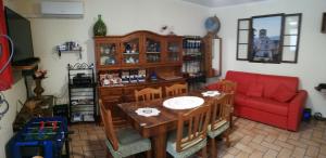 阿西西玛丽亚之家度假屋的客厅配有桌子和红色沙发