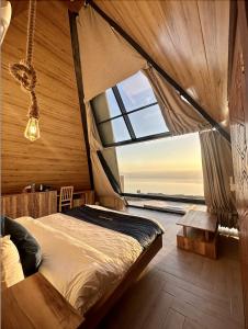 马达巴Deadsea OCTAGON的一间卧室设有一张床和一个大窗户