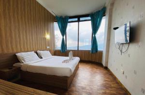 乌提Tulips Resorts - Elkhill的一间卧室设有一张床和一个大窗户