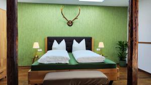 韦尼格罗德Traditions - Hotel "Zur Tanne"的一间卧室配有一张带绿色墙壁的床