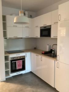 华沙Chopin airport Apartment的厨房配有白色橱柜和炉灶烤箱。