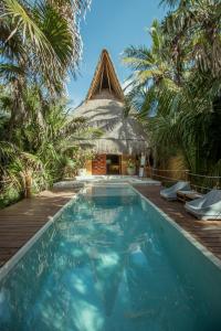 图卢姆Casa Nalum的一个带游泳池和茅草屋顶的度假胜地