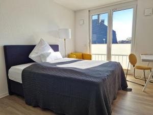 比勒费尔德Stadt-Appartement CityLife的一间卧室设有一张大床和大窗户