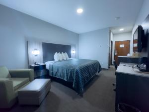 Madill马迪尔美国酒店的配有一张床和一把椅子的酒店客房