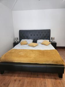 贝克斯利黑思Cosy Studio Flat的一间卧室配有一张带黄色枕头的床。