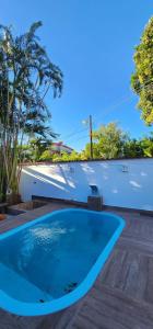 曼加拉蒂巴Casa em mangaratiba的木制甲板上的蓝色游泳池