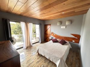 蒙泰韦尔德哥斯达黎加Monteverde Ecolove的一间卧室设有一张床和木制天花板