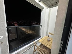地拉那107 Dreams的阳台配有桌子和大窗户。