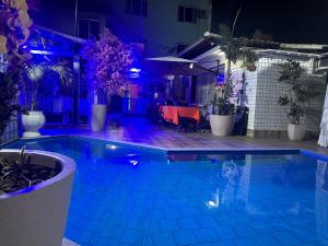 里约热内卢Hotel Pousada Irmaos Freyhardt的游泳池晚上有紫色灯光