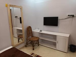 古瓦哈提GOVARDHAN HOME STAY ( Munna )的客房设有书桌、电视和椅子