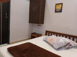古瓦哈提GOVARDHAN HOME STAY ( Munna )的卧室内的一张带两个枕头的床