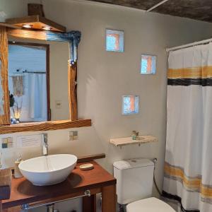德尔迪阿布罗角Cabañas Bahia Serena的一间带水槽、卫生间和镜子的浴室