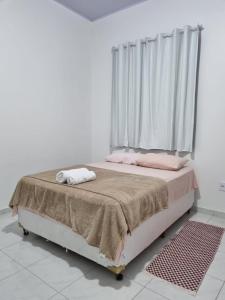 巴雷里尼亚斯Pousada Talismã的一间卧室配有带粉红色枕头的床和窗户。