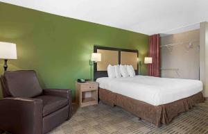 休斯顿美国长住酒店 - 休斯顿 - 广场 - 住宅区的配有一张床和一把椅子的酒店客房