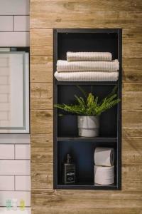 格拉斯哥SleepLuxury ApartHOUSE的浴室里摆放着带毛巾和植物的架子
