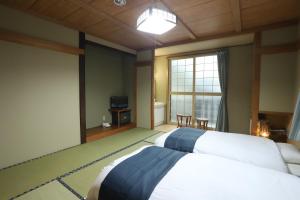 野沢内田屋旅馆的一间卧室设有两张床和大窗户