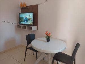 彼得罗利纳Kitnet Vila Marcela的白色的餐桌、椅子和电视