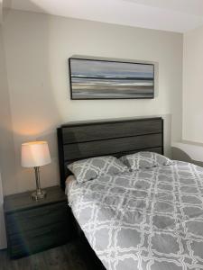 纳奈莫Modern 2BR Guest House in North Nanaimo的卧室配有一张床,墙上挂着一幅画