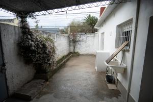 米纳斯Casa amueblada en centro de Minas, Lavalleja的一条空洞的小巷,有白色的墙壁和水槽