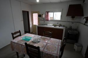 米纳斯Casa amueblada en centro de Minas, Lavalleja的厨房配有桌椅和炉灶。