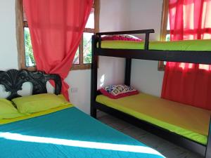 CalaoHospedaje Paula C的配有红色窗帘的客房内的两张双层床