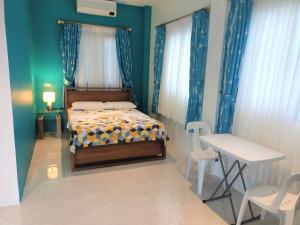 邦劳Alona WhiteHouses Resort的卧室配有一张床和一张桌子及椅子