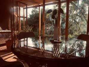 基多Cozy and isolated with hot springs的一个带椅子的玻璃桌,位于带游泳池的庭院