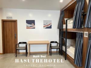 迪石Hasu The Hotel的客房设有双层床和桌椅。