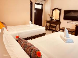 清迈Na Thapae Chiangmai Hotel的酒店客房设有两张床和一台平面电视。