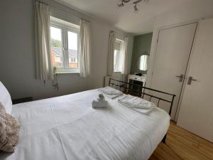 曼彻斯特Manchester 2 Bedroom House with Garden的卧室内的一张白色床,设有窗户