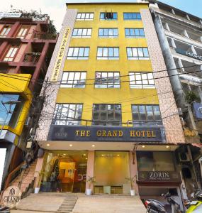 艾藻尔The Grand Hotel的黄色的建筑,街道上有一家大酒店