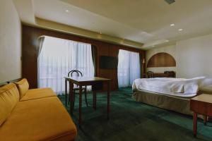 台南天下南隅 Provintia Hotel的酒店客房配有床、桌子和沙发。