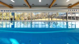 波高尔宾Elysia Wellness Retreat的一座大型游泳池,位于一座带大窗户的建筑内
