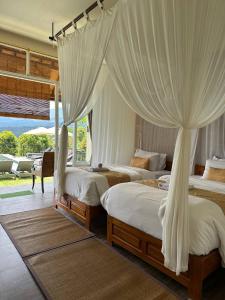 姆杜克Atres Sari Resort的卧室配有2张带白色窗帘的床