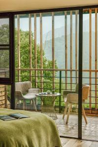 德清听涧·莫干山椿山集景观民宿的一间卧室设有一张床和一个美景阳台