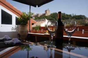 格拉纳达ADANAR-Apartamentos Muralla Zirí的2杯葡萄酒和1瓶餐桌葡萄酒