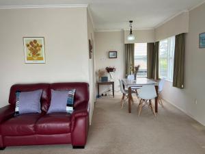 汉密尔顿Glenview home的客厅配有红色皮革沙发和桌子