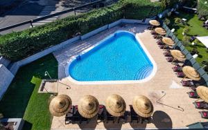 马德里纽沃波斯顿酒店的享有带椅子和遮阳伞的游泳池的上方景色