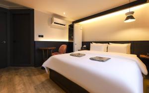 堤川市STAY201的酒店客房设有一张白色大床和一张桌子。