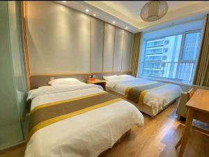 青岛青岛水云涧公寓式酒店的酒店客房设有两张床和窗户。