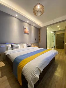 青岛青岛水云涧公寓式酒店的一间卧室配有一张大床,床上铺有黄色和蓝色的毯子