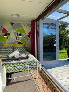 RossRoss Beach TOP10 Holiday Park的卧室配有滑动玻璃门旁边的床