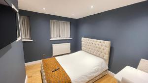 克罗伊登Apartment & Rooms in London的一间卧室设有一张床和蓝色的墙壁