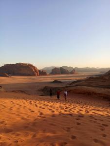 亚喀巴Bedouin experiences的日落时分两人在沙漠中漫步