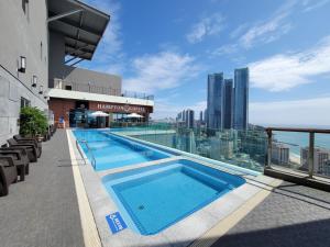 釜山Best Travel in Haeundae with best location的建筑物屋顶上的游泳池