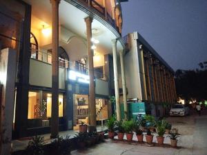 阿格拉Hotel Tara Palace by Goyal Hoteliers的前面有盆栽植物的大建筑